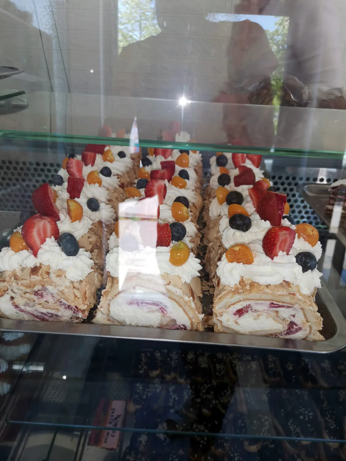 Felii de tort cu fructe, expuse în vitrina frigorifică