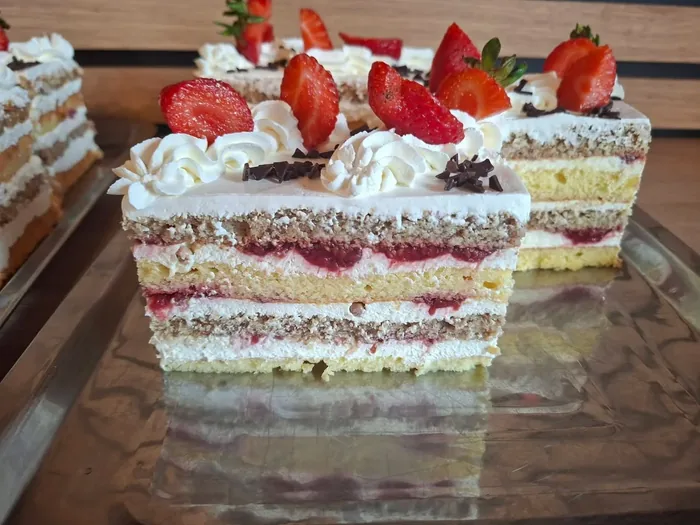Felii de tort cu frișcă și căpșuni, în vitrină