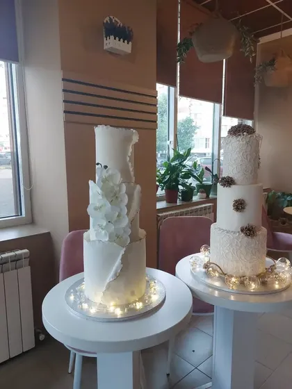 Tort de nuntă cu flori albe sculptate, pe suport luminat