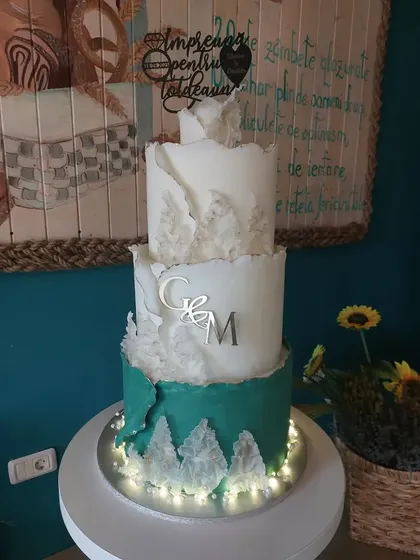 Tort de nuntă cu monogramă, bază turcoaz și floarea-soarelui